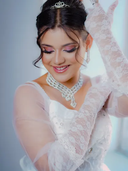 The lace gloves and gentle smile add to the timeless elegance of this classic bridal look.