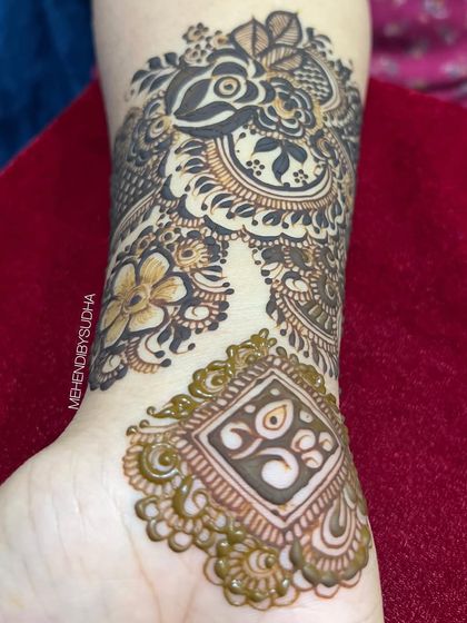 A close-up of a beautiful Indo-Arabic wrist design, featuring a mix of floral and geometric patterns.