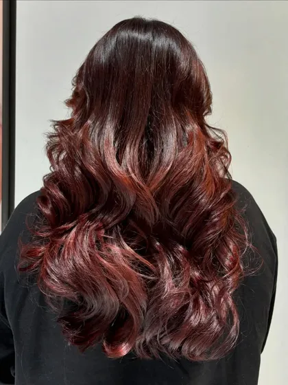 The back view of the auburn transformation, styled in soft curls to show off the color's dimension.