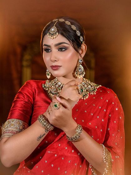 Another portrait of the red lehenga bride, showing the intricate details of the jewelry and makeup.