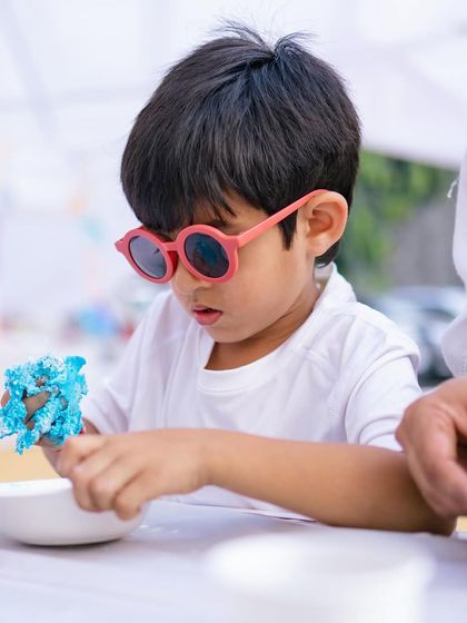 A cool little guest focused on his sand art creation. These hands-on activities are great for developing creativity and fine motor skills.