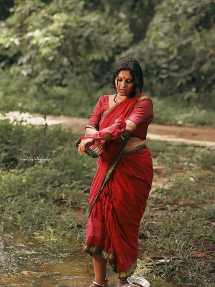 A rustic, village-themed series inspired by the movie 'Kanthara'. The model is styled in a simple red saree, captured in a natural, watery landscape to evoke a sense of raw, earthy beauty.