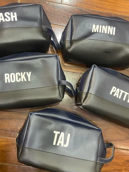 Personalized travel pouches with the cast and crew's character names or nicknames, like 'Patty', 'Rocky', and 'Bash'.