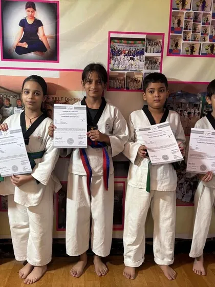 A group of our dedicated taekwondo students proudly display their certificates after grading up. You can see a mix of different belt levels, showing the path of progression in our program.