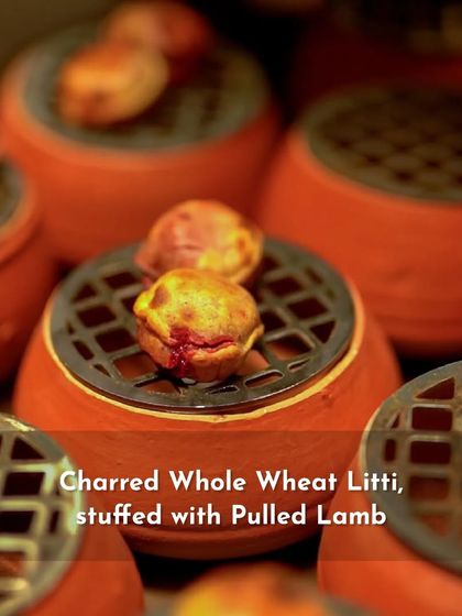 A close-up of my charred whole wheat litti, stuffed with savory pulled lamb. The individual terracotta pots are not just for serving; they are part of the cooking and presentation process.