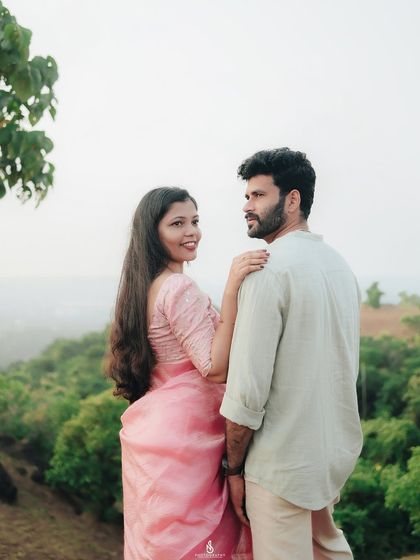 A lovely pose overlooking a valley of green hills. This shot combines an intimate moment with a grand, scenic landscape.