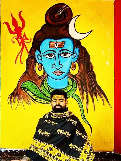 Meditation in front of a vibrant mural of Lord Shiva. The external environment can inspire the internal journey, creating a powerful atmosphere for spiritual practice and reflection.