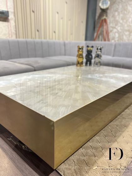 An ultra-luxury center table crafted from selenite stone with a brushed brass base. The natural, crystalline texture of the selenite top makes this a unique and captivating centerpiece.