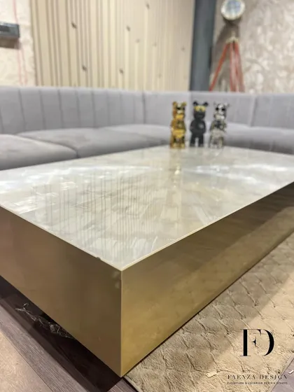 An ultra-luxury center table crafted from selenite stone with a brushed brass base. The natural, crystalline texture of the selenite top makes this a unique and captivating centerpiece.