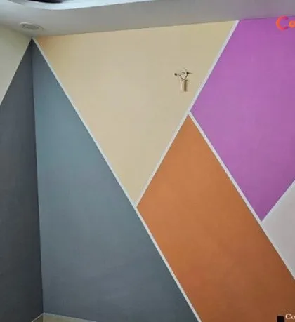 This accent wall features a bold, multi-colored geometric pattern. Using painter's tape and a vibrant color palette, we created a modern and energetic design that completely revitalizes the room's corner.