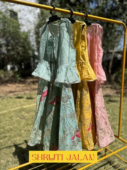 A full view of my pastel lehenga sets on a rack, showcasing the variety of colors available. From mint green to blush pink, there's a shade for every little diva.