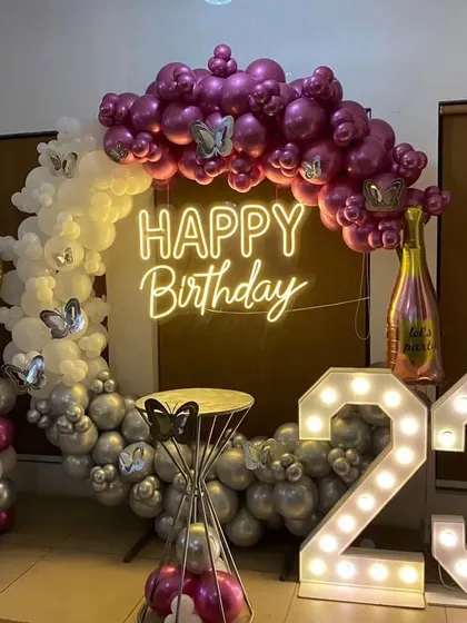 A close-up of the 23rd birthday decor, highlighting the champagne bottle foil balloon and butterfly details.
