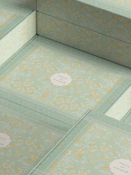 A stack of the custom-designed invitation boxes. The delicate pattern and personalized monogram make these boxes a beautiful keepsake for guests long after the wedding.
