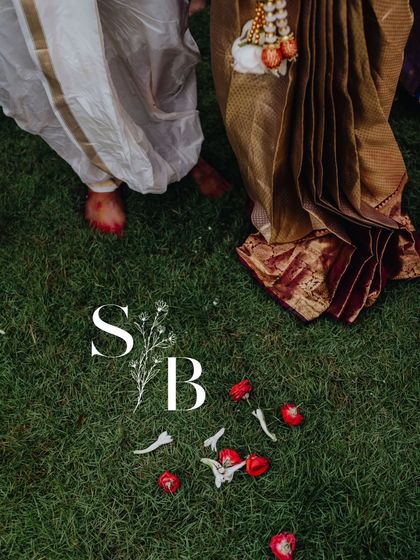An artistic shot of the couple's feet on the grass with scattered petals, a simple yet beautiful representation of their journey together.