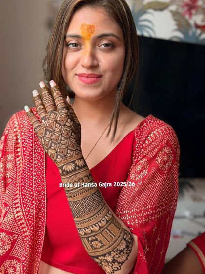 A happy bride showing off her full back-of-hand design. The pattern extends all the way up her arm, creating a statement look that is both bold and beautiful.