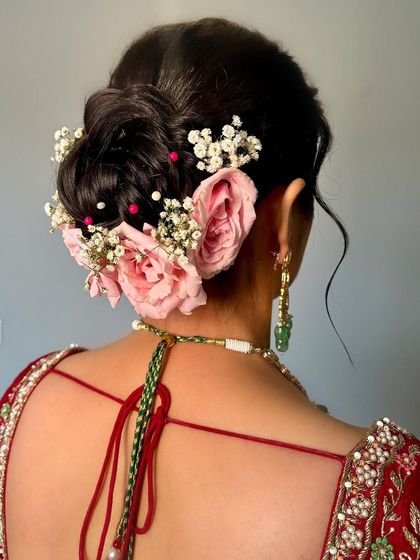A detailed shot of the beautiful floral hair bun, adding a romantic and traditional touch to this bride's look.