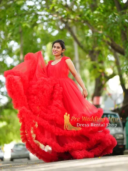 Capturing the beautiful movement of the red ruffled gown as it's tossed in the air. The layers of tulle create a spectacular, full shape that brings energy and life to maternity photos.