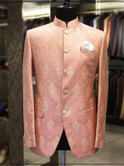 A pink brocade bandhgala jacket with a subtle leaf pattern. This is a fresh and modern color choice for traditional wear, ideal for daytime events.