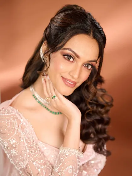 A beautiful portrait that highlights the radiant skin and sparkling eyes of this reception look. The soft waves and delicate jewelry perfectly complement the understated yet glamorous makeup.