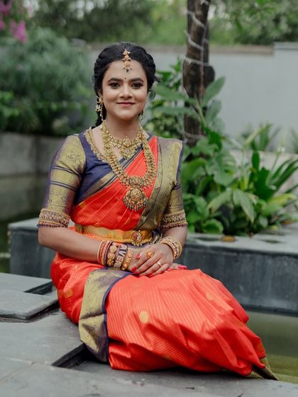 A seated portrait of the bride. The rich colors of her saree and her traditional gold jewelry are the highlight of this stunning photo.