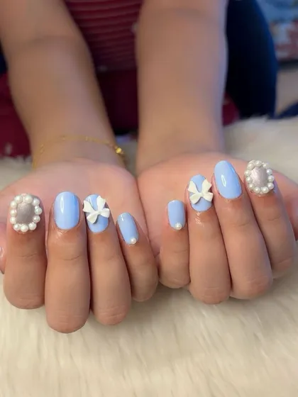 A full view of the perfectly symmetrical coquette nail art.