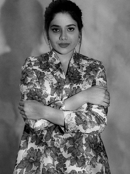 A classic black and white portrait of Karunya. This timeless photo showcases her strong features and confident presence.