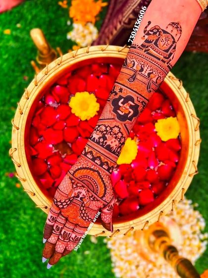 An artfully composed shot of a traditional mehandi arm over a bowl of rose petals, highlighting auspicious symbols like the swastika and elephant.