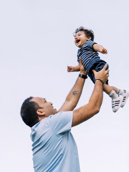 A father tossing his laughing son in the air. A classic shot that never fails to capture pure happiness.