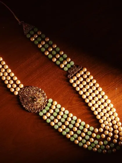 A close-up of the groom's traditional necklace. This detail shot showcases the elegance and style of the groom's wedding accessories.