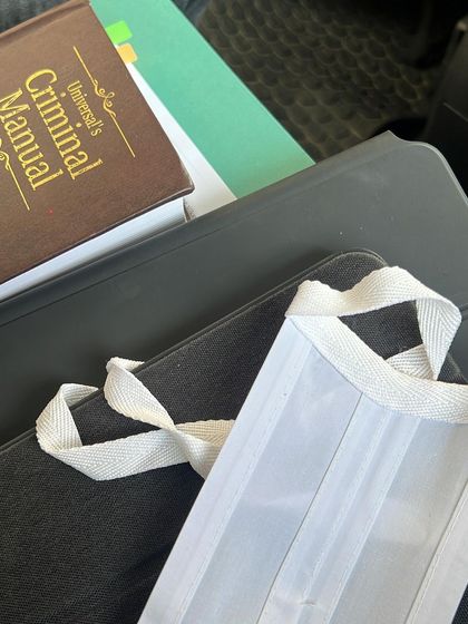 The tools of my trade on a Saturday: a criminal manual, case files, and my iPad. Weekends are often dedicated to trial preparation and cross-examinations.