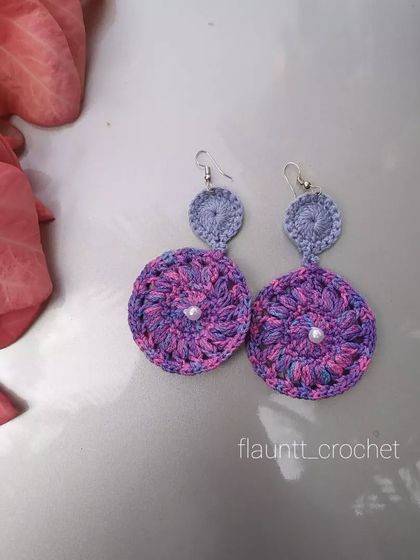 I love the variegated purple yarn used in these two-tiered circular earrings. The little pearl in the center adds a touch of elegance.