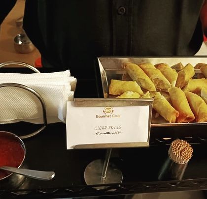 A tray of our crispy cigar rolls, ready to be served to guests at a birthday party.