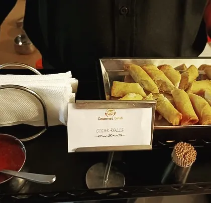 A tray of my delicious cigar rolls being served to guests. I ensure my passed appetizers are always hot, fresh, and presented with a professional touch.