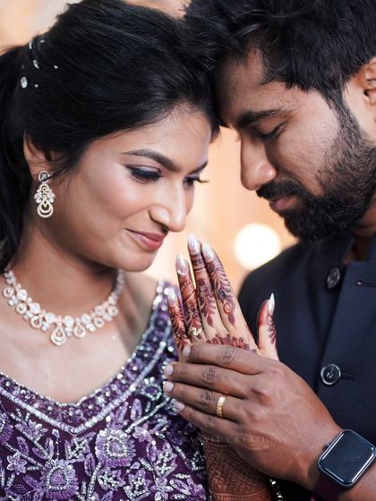 A tender moment focusing on the bride's henna-covered hand and the new engagement ring.