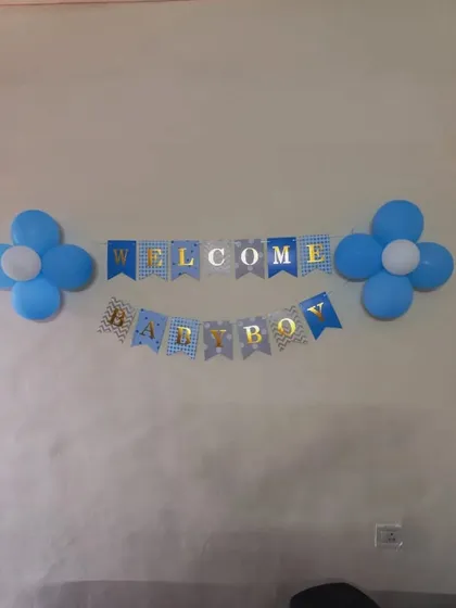 A simple 'Welcome Baby Boy' banner flanked by blue and white balloon flowers, perfect for a subtle wall decoration.
