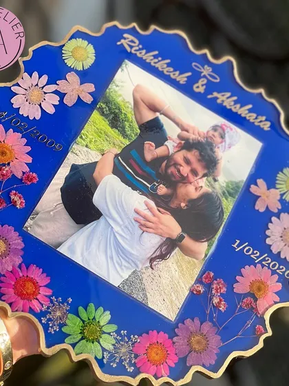 This bold blue frame beautifully captures a family's journey. It includes important dates and a cherished family photo, all surrounded by a border of vibrant, hand-placed flowers.