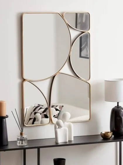 An example of our abstract, multi-panel mirror designs. This piece, with its elegant gold frame, combines different geometric shapes to create a unique and artistic focal point above a console table. We work with you to design custom configurations that fit your wall space perfectly.