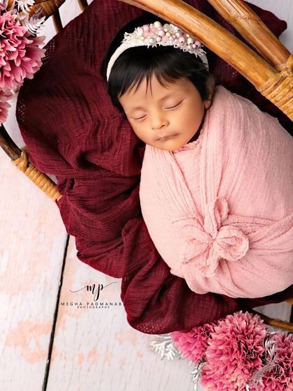 A close-up portrait, focusing on the baby's serene face and the delicate headband.