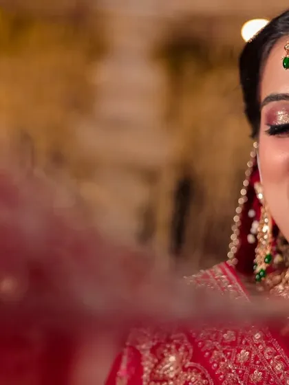 A joyful, smiling portrait of the bride, her face partially veiled, capturing a moment of pure happiness at her destination wedding.