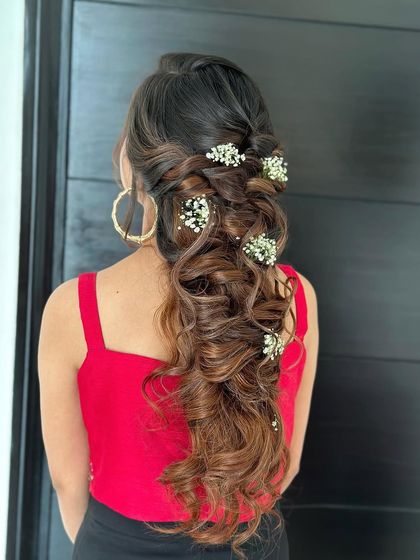 A braided floral look. This side-swept braid is adorned with baby's breath, creating a soft, romantic, and bohemian vibe.