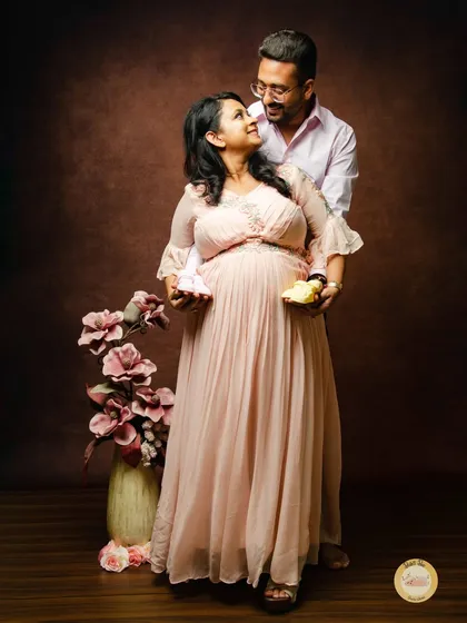 Holding tiny baby shoes together is a beautiful way to symbolize the new life you are waiting for. This classic studio portrait has a warm, sentimental feel.