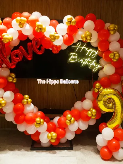 A heart-shaped balloon frame in red, white, and gold. This decoration includes "Love" and "Happy Birthday" signs, making it a perfect photo booth for a 9th birthday or an anniversary.