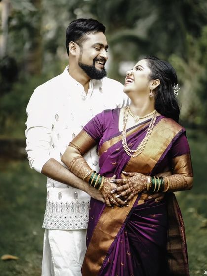 A joyful and candid portrait of the couple, sharing a laugh in a beautiful garden setting.