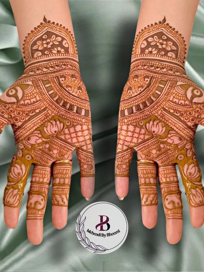 A lovely symmetrical design featuring lotuses and peacocks. The fingers are detailed with tiny elephants, adding a playful touch to this elegant bridal mehendi.
