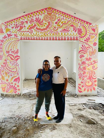 With the proud owner of the 'Baba's Garden' mural. The best part of my job is seeing the joy my art brings to people and their homes.