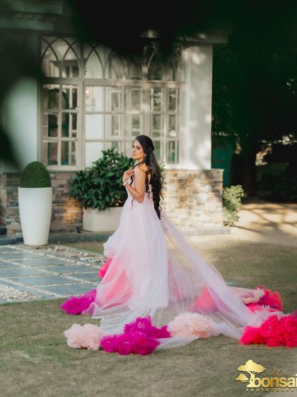 A beautiful, candid-style shot of the bride in her magnificent gown, framed by the garden's greenery.