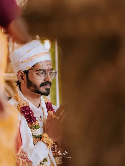 A thoughtful portrait of the groom during the ceremony, captured through a creative frame.