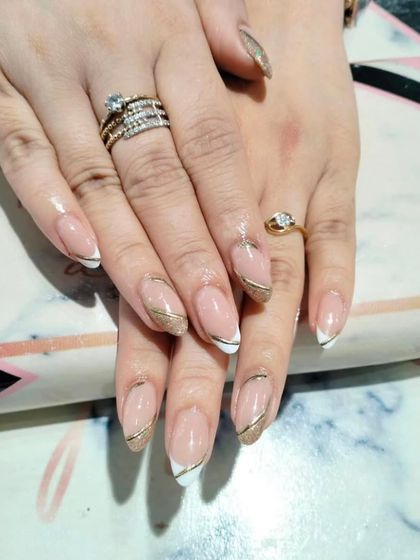 A sophisticated design featuring a classic white French tip elegantly separated by a clean, curved gold line.