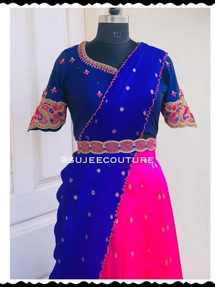 A closer look at the half saree ensemble. The royal blue blouse features delicate embroidery on the neckline and sleeves, and the look is completed with a custom-embroidered vaddanam (belt).
