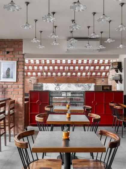 The interior of Klaa Kitchen, designed to evoke the feeling of a Goan home. We used exposed brick, a bright red service counter, and a collection of frilled pendant lights to create a space that is casual, warm, and full of character.